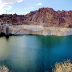 Hoover Dam - brown wooden dock on river near brown mountain under blue sky during daytime