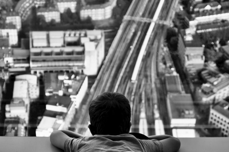 Shard London - grayscale photo of man sitting on the floor