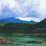 Statue Of Unity - green mountain beside body of water under cloudy sky during daytime