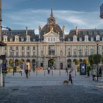 Place République - a group of people walking down a street next to tall buildings