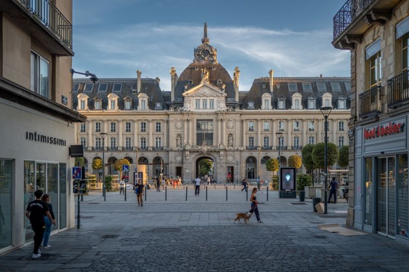 Place République - a group of people walking down a street next to tall buildings