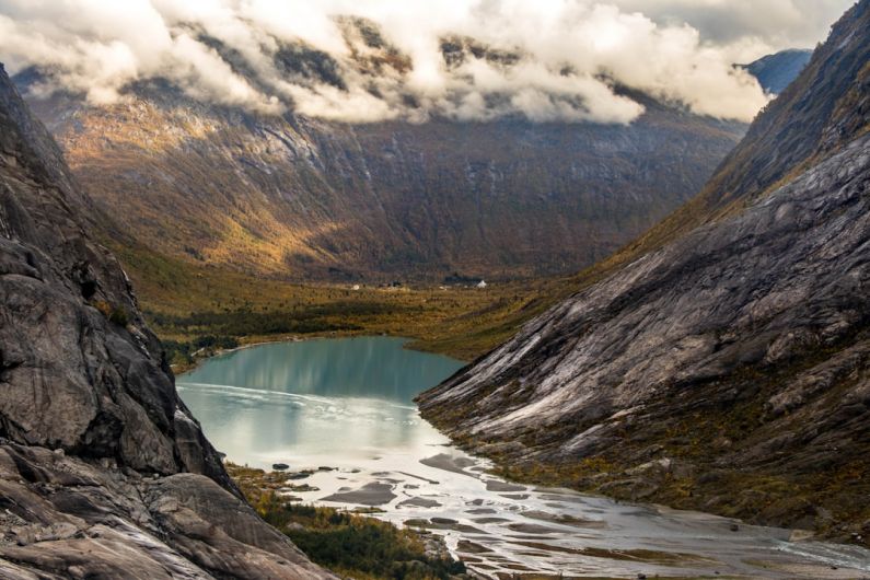 Cliffside Norway - landscape photography of body of water between mountain