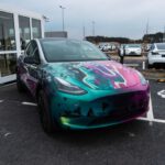 Gigafactory - a colorful car parked in a parking lot