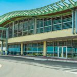 Green Airport - a large building with a green roof and a curved walkway