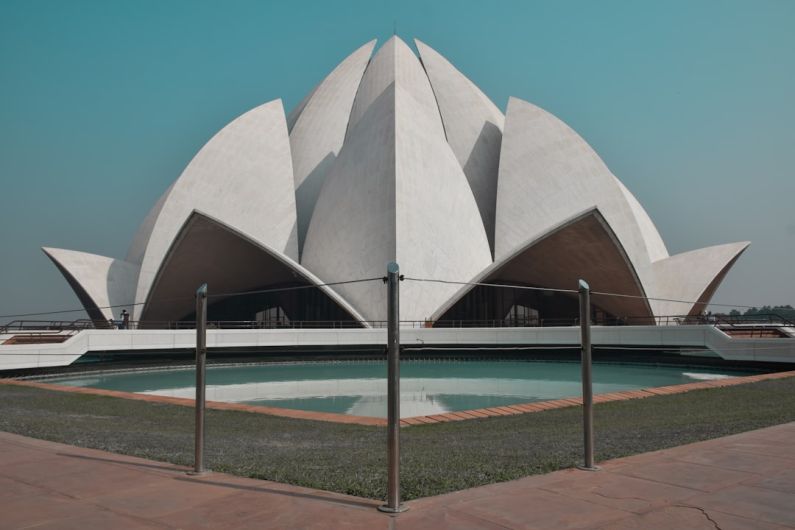 Lotus Temple - white concrete building near body of water during daytime