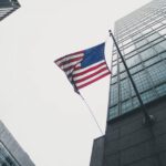 Shibam Skyscrapers - flag of America waving under gray skies