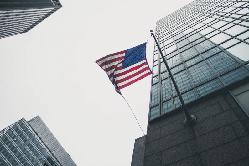 Shibam Skyscrapers - flag of America waving under gray skies