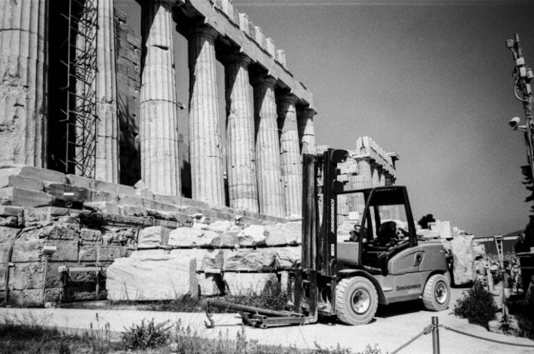 Acropolis Restoration - a black and white photo of a forklift in front of a building