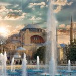 Hagia Sophia - fountain in front of brown concrete building under cloudy sky during daytime