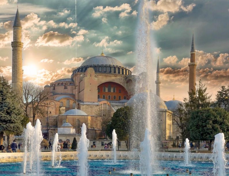 Hagia Sophia - fountain in front of brown concrete building under cloudy sky during daytime