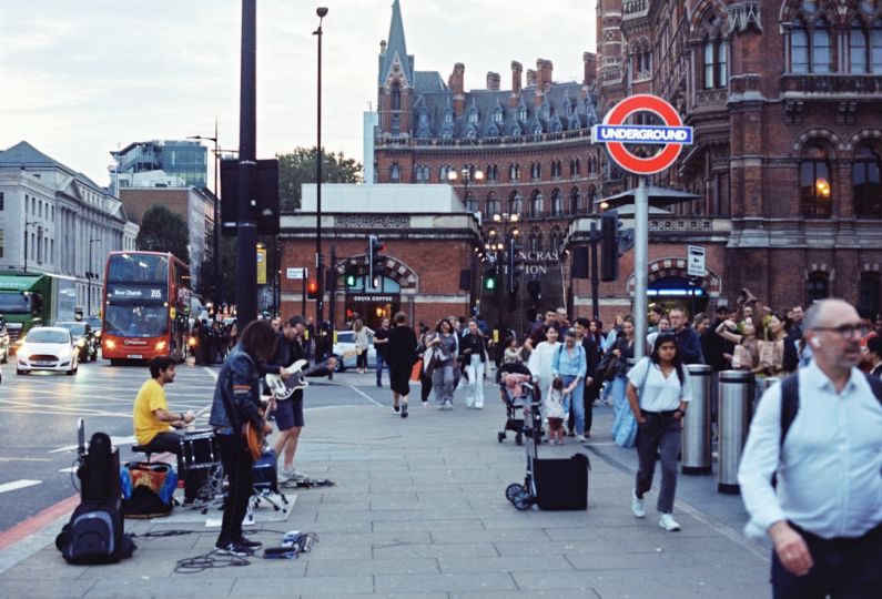 St. Pancras - a group of people walking down a street next to a traffic light