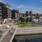 Waterfront Development - people walking on sidewalk near body of water during daytime