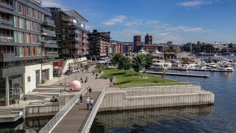 Waterfront Development - people walking on sidewalk near body of water during daytime