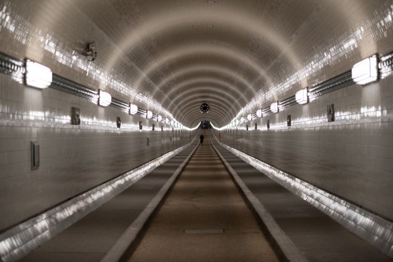 Underwater Tunnel - people walking on hallway with lights turned on during night time