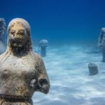Underwater City - a statue of a man and a woman in the water