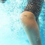 Underwater Hotel - a woman in a leopard print swimsuit under water