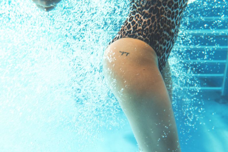 Underwater Hotel - a woman in a leopard print swimsuit under water