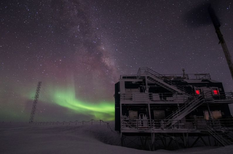 Mariana Observatory - white multi-storey building under starry night and northern lights