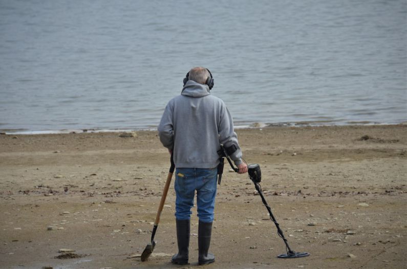 Sunken Treasure - a man with crutches and a cane standing on a beach