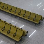 Green Airport - two rows of yellow chairs sitting on top of a floor