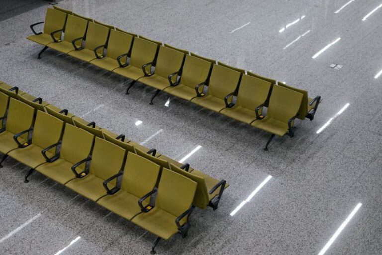 Green Airport - two rows of yellow chairs sitting on top of a floor