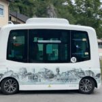 Autonomous Vehicles - a white bus parked on the side of a road