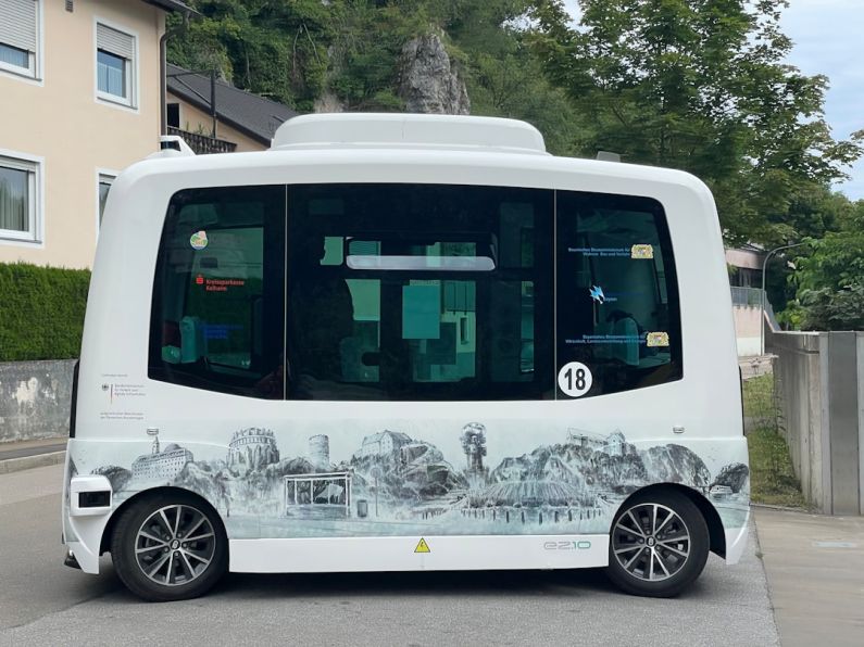 Autonomous Vehicles - a white bus parked on the side of a road