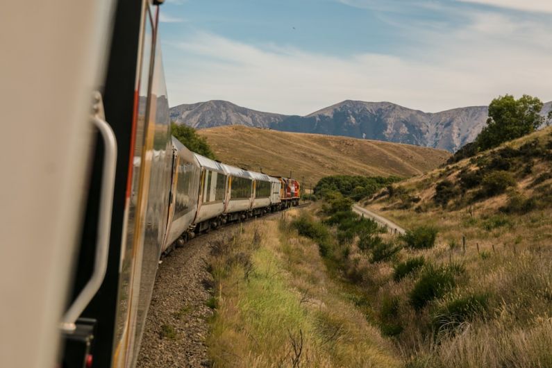 Maglev Train - white train with the distance of mountain during daytime