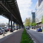 Elevated Bike Lane - cars parked on the side of the road under a bridge