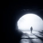 Transatlantic Tunnel - silhouette of person walking out from tunnel during daytime