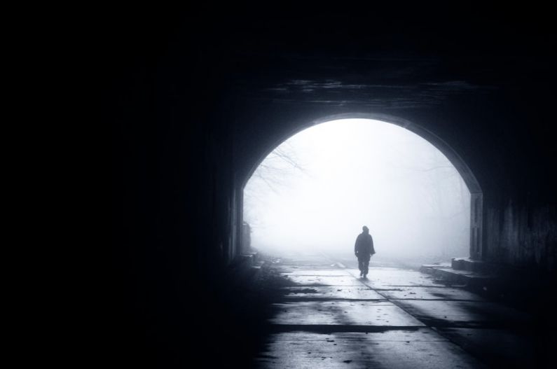 Transatlantic Tunnel - silhouette of person walking out from tunnel during daytime