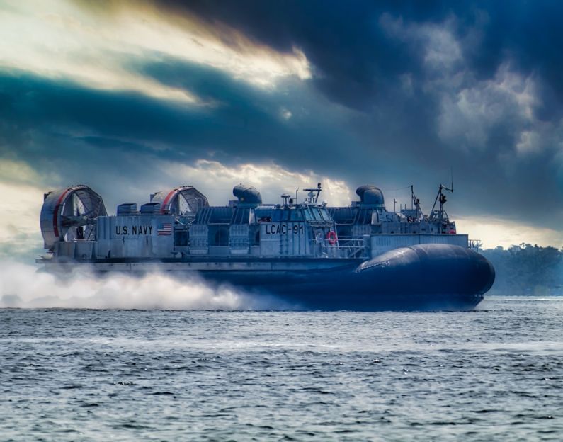 Hovercraft - blue and white ship on sea under cloudy sky during daytime